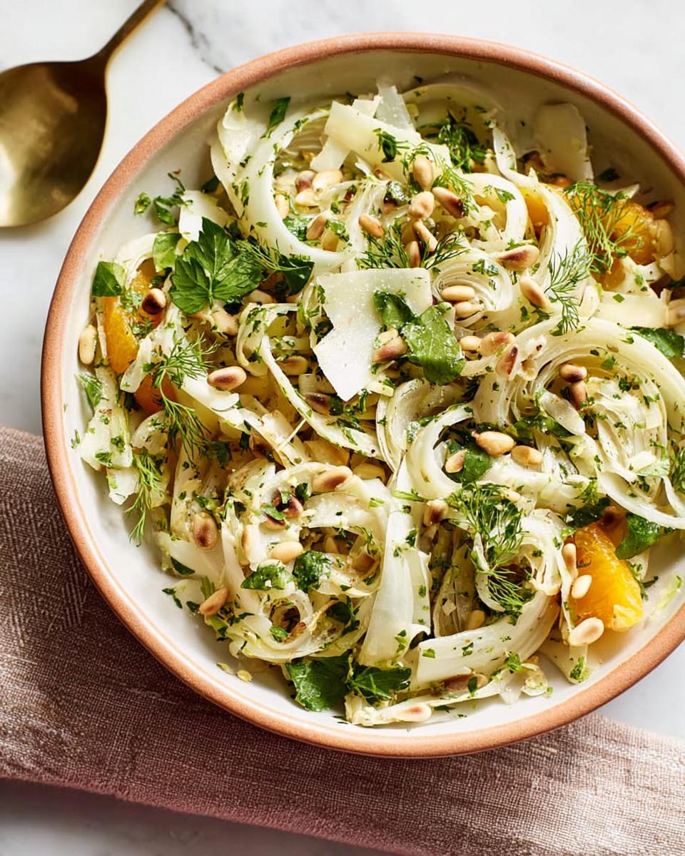 A refreshing Thanksgiving salad featuring thinly sliced fennel, orange segments, pine nuts, and fresh herbs.